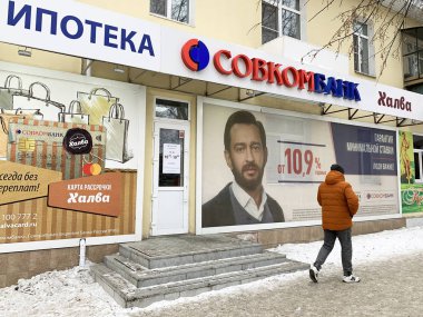 Kyshtym, Rusya, 15 Ocak 2020. Kışın, Kyshtym kasabasında, Rusya Merkez Bankası 'nın önünden geçen adam. Rusya, Chelyabinsk bölgesi