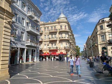 Bakü, Azerbaycan, Eylül, 09: 19. Güneşli bir günde, sonbaharda Nizami caddesinde tarihi binaların yakınında yürüyen insanlar. 77. ve 79. evler. Azerbaycan, Bakü şehri