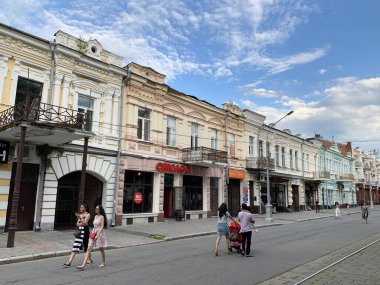 Hughkavkaz, Rusya, 28 Haziran 2019. Bulutlu bir yaz gününde Mira Bulvarı boyunca yürüyen insanlar. 20, 18, 16, 14 numaralı evler. Kuzey Osetya-Alanya Cumhuriyeti