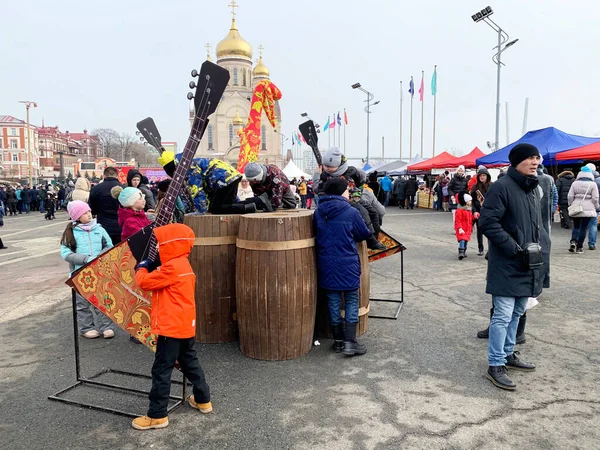 ロシアのウラジオストク2020年3月1日 マレニッツァのお祝いの間 革命戦闘機の広場にBalalaikaを使用して美術品の近くを歩く人々 ロシアのウラジオストク — ストック写真