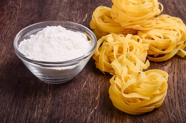 Tagliatelle and flour on the table — Stock Photo, Image