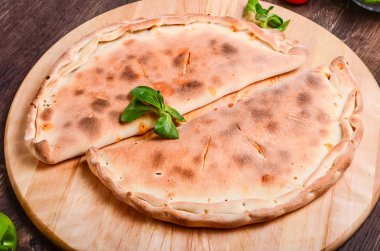 Calzone pizza. Pizza üzerinde koyu renkli ahşap tablo