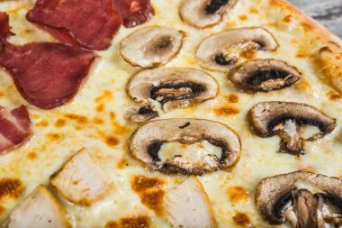 Pizza dört parçalar, rosemary ile ve baharat üzerine bir ışık ahşap 