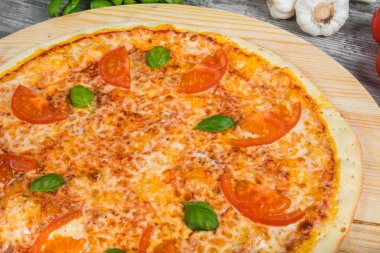 İtalyan pizza üzerinde sebze ve yeşillik zemin üzerine ahşap masa lambası