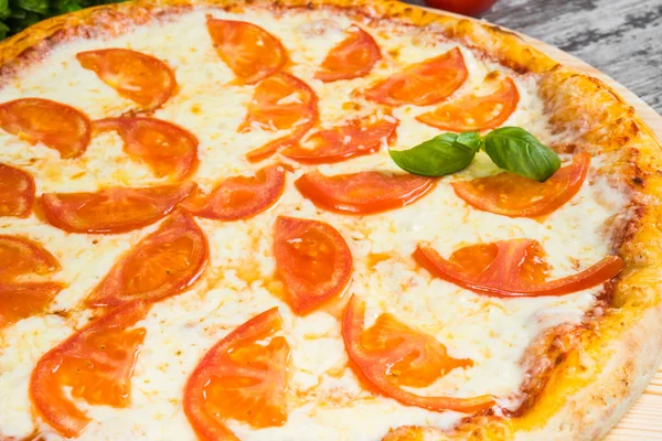 Pizza s rajčaty, s rozmarýnem a koření na světlo dřevěné — Stock fotografie