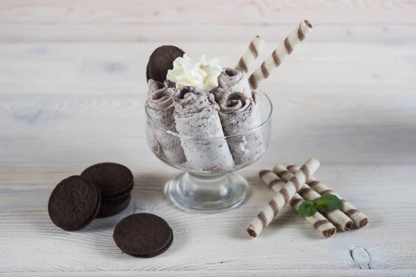 Roll of ice cream with crushed chocolate cookies. Fresh fried ic