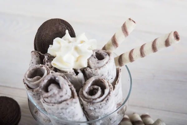 Roll of ice cream with crushed chocolate cookies. Fresh fried ic