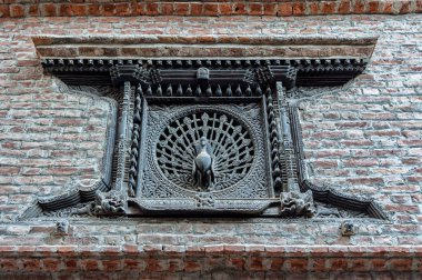 Tavuskuşu Penceresi, 15. yüzyılın başlarında merkezindeki Dattatraya Meydanı açıklarında, Bhaktapur, Nepal 'de karmaşık şekilde oyulmuş bir tavus kuşu yuvası olan bir pencere.