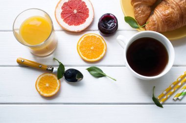 Düz yatıyordu. Bir fincan kahve ve portakal suyu ahşap bir masa üzerinde