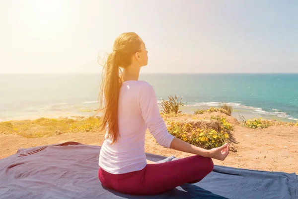 Una joven yoga en la playa del mar — Foto de Stock