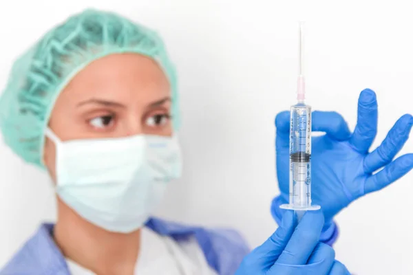 Doktor hemşire eldivenli bir şırınga tutar