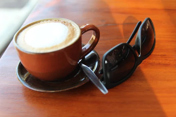 Uma Xícara Café Com Óculos Sol Mesa — Fotografia de Stock