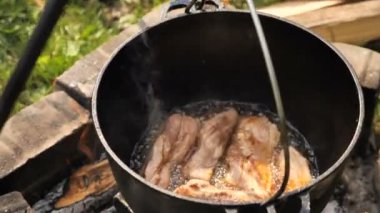 Açık havada kazanda et pişirmek. 