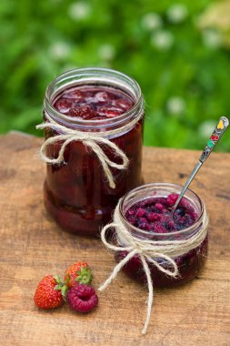 Ahşap arka planda bir kavanozda çilek reçeli