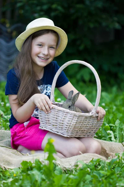 Симпатичная девушка, держащая корзину с кроликом — стоковое фото