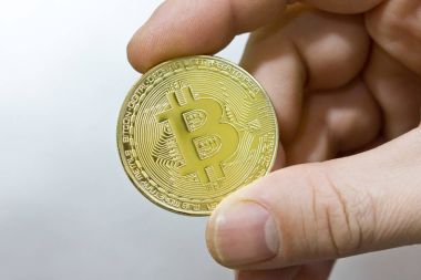 Elinde, closeup altın bitcoin.