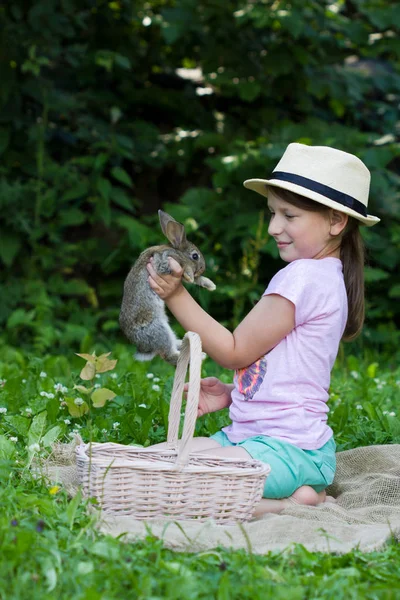 Niedliches Kleines Mädchen Hält Einen Korb Mit Einem Kaninchen — Stockfoto