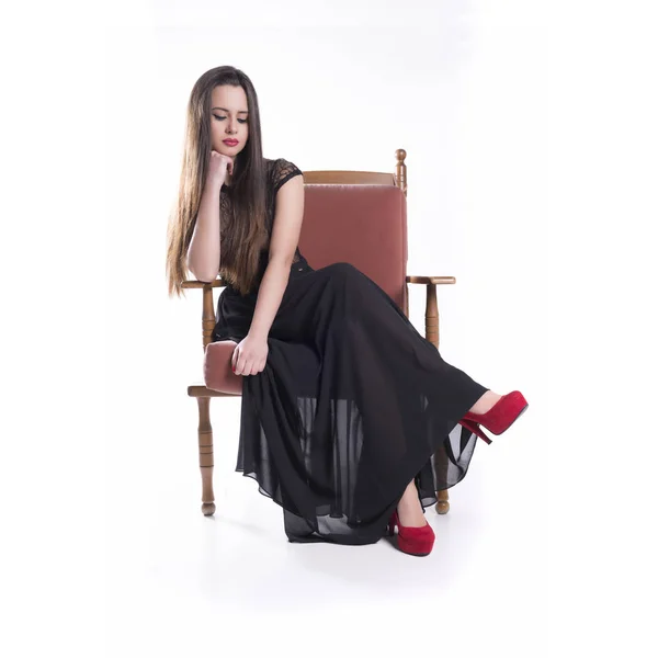 Молодая модель в черном платье сидеть — стоковое фото