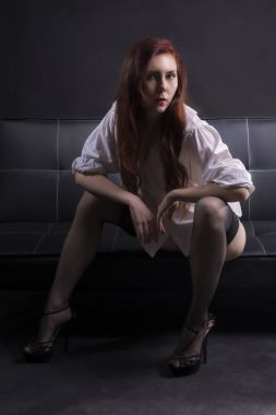 Siyah deri kanepe üzerinde seksi kadın