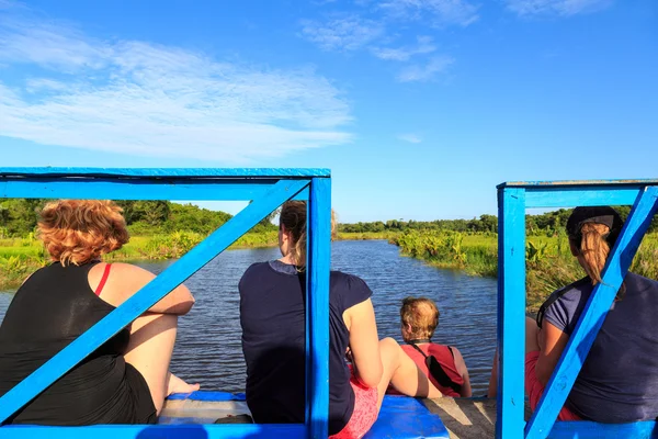 Donne sedute sul retro di una barca godendo della vista di un verde — Foto Stock