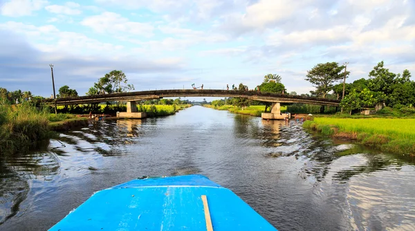 Kanal med bro sett från en båt i en tropisk natur — Stockfoto