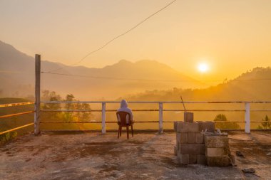 Ormanın ve dağların gündoğumunun tadını çıkaran kişi, yaz