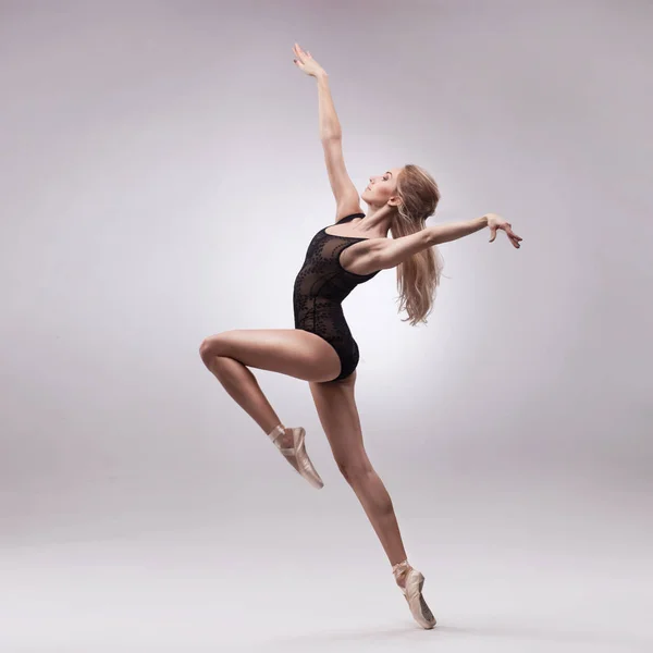 Bailarina em roupa preta posando nos dedos dos pés — Fotografia de Stock