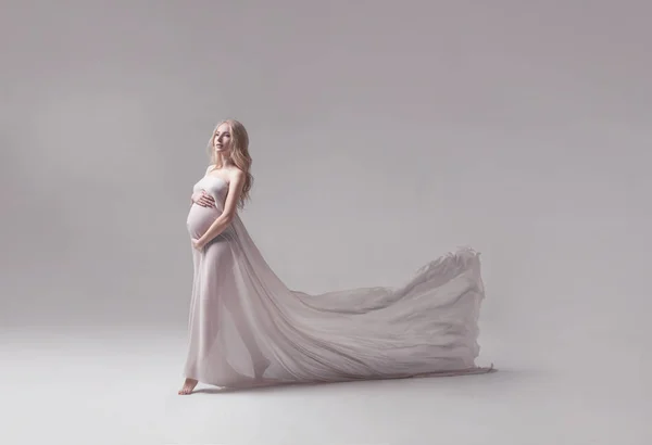 Mulher jovem grávida em vestido branco voador — Fotografia de Stock