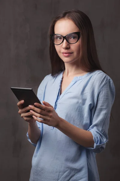 Portret van mooie gelukkig jonge vrouw met glazen ebook lezen — Stockfoto