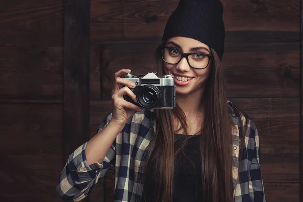 Улыбающаяся девушка в очках с винтажной камерой — стоковое фото