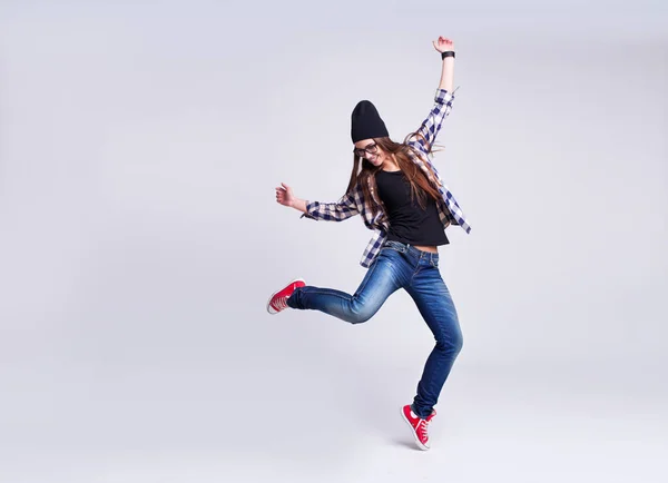 Ballando hipster ragazza in occhiali e berretto nero — Foto Stock