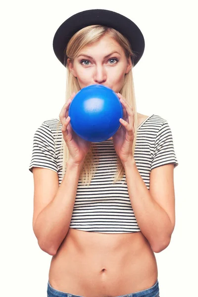 Νεαρή γυναίκα φυσώντας μπλε μπαλόνια — Φωτογραφία Αρχείου