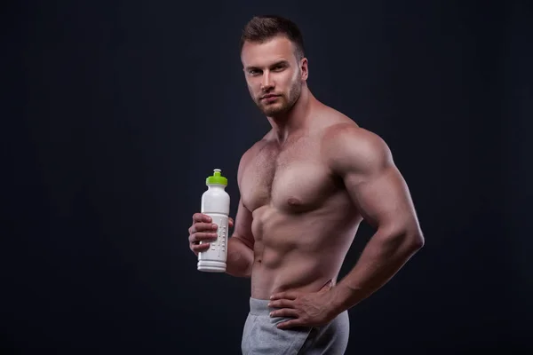 М'язистий чоловік з тримає пляшку — стокове фото