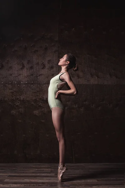 Mladé krásné baletky v zelené plavky pózuje na pointes — Stock fotografie