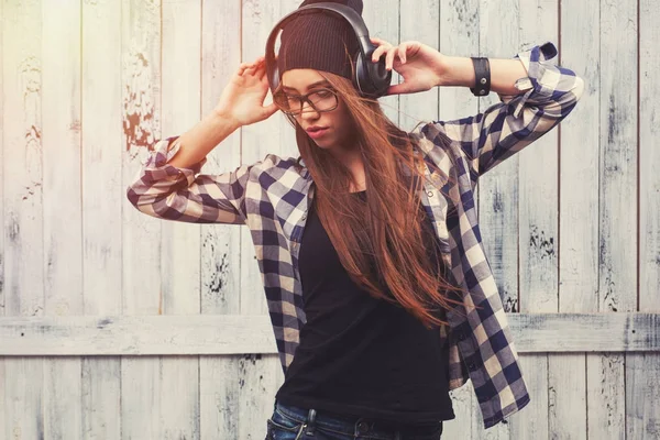 Hipster-Mädchen mit Brille, Kopfhörer und schwarzer Mütze — Stockfoto