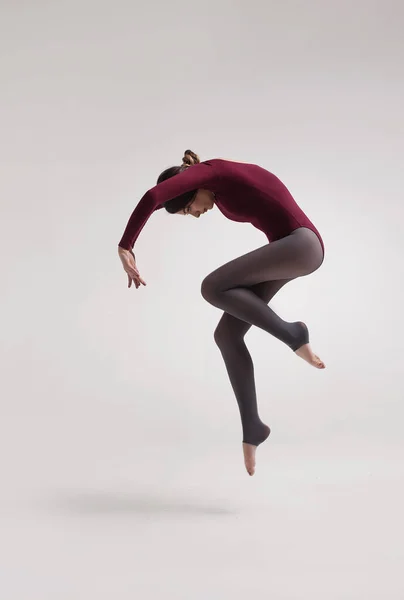 Jonge vrouw danser in kastanjebruine badpak springen — Stockfoto
