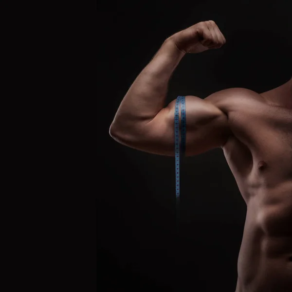 Człowiek mierzy biceps z taśma miernicza — Zdjęcie stockowe