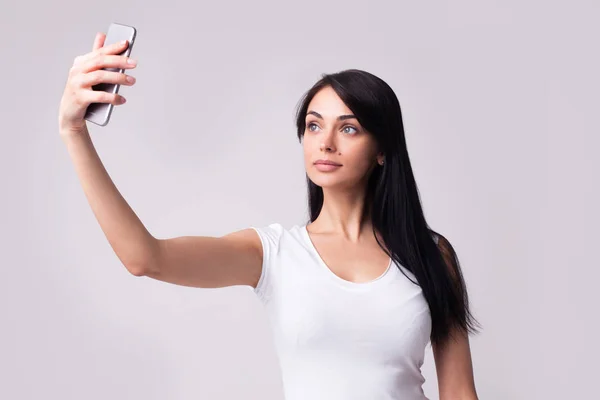Μελαχρινή νεαρή γυναίκα σε casual ρούχα κάνοντας selfie — Φωτογραφία Αρχείου