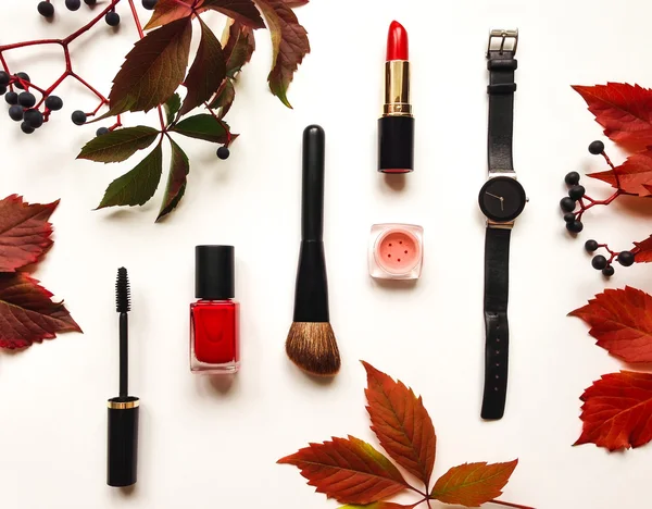 Decorative flat lay composition with cosmetics, woman accessories and autumn leaves and berries. Flat lay, top view Stock Picture