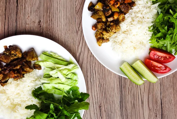 ヘルシーなランチと 2 つのプレートの平面図です。白いご飯、タイ揚げ肉、野菜。フラット木製の背景の上に置く — ストック写真