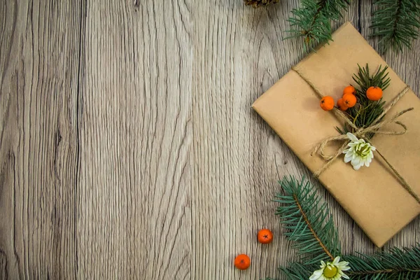 Presente de Natal embrulhado em papel kraft com decoração natural. Deitado plano, vista superior — Fotografia de Stock