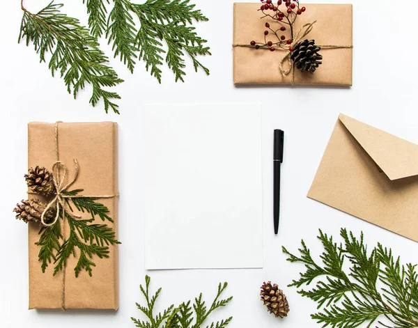 Caixas de presente em papel ecológico e uma carta sobre fundo branco. Natal ou outro conceito de férias, vista superior, flat lay — Fotografia de Stock