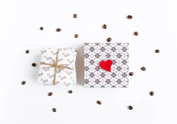 Handgemachte Geschenke auf weißem Hintergrund mit Herz und Bund verziert — Stockfoto