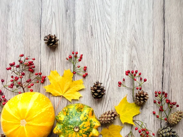 南瓜、 秋天的落叶和浆果的时尚组合。木制的背景上的顶视图。秋平躺 — 图库照片