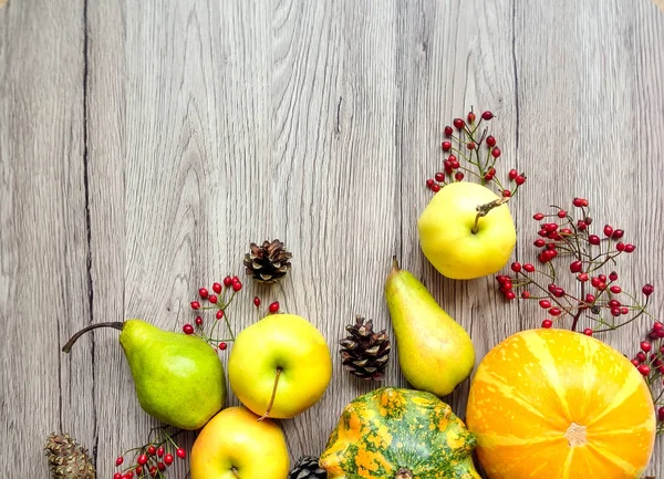 Stylish composition of pumpkins, autumn fruits and berries. Top view on wooden background. Autumn flat lay