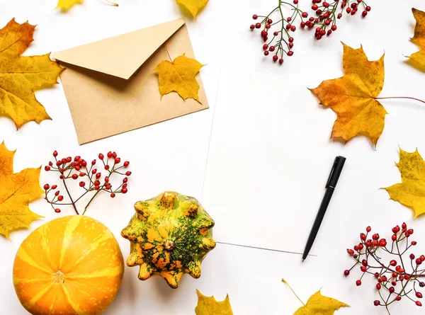 Stijlvolle samenstelling van brief, pompoenen, bladeren, bessen. Bovenaanzicht op witte achtergrond. Herfst plat leggen Stockfoto