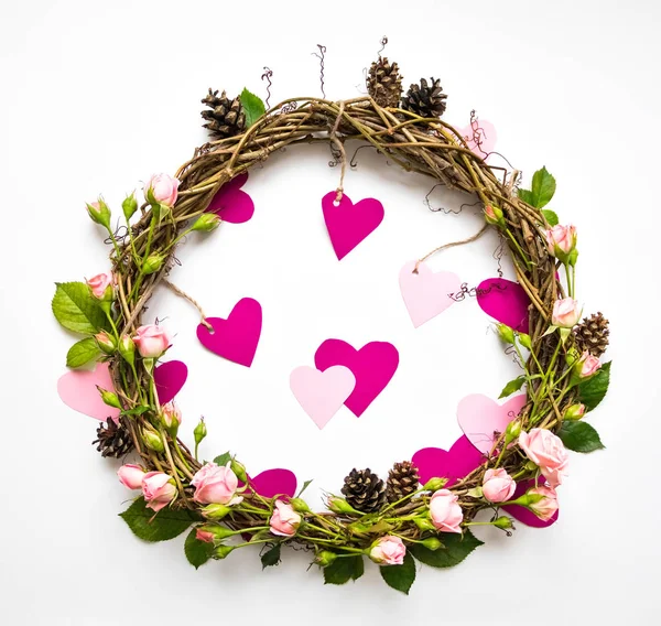 Festkranz aus Weinreben mit dekorativen Rosen und rosa Papierherzen. flache Lage, Draufsicht — Stockfoto