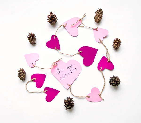 Corações de papel rosa brilhantes unidos com uma corda do dia de Valentim. Flat lay no fundo branco — Fotografia de Stock