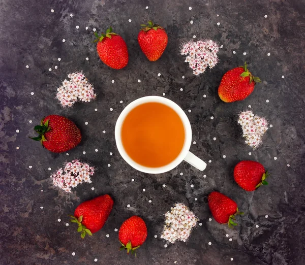 Colorida composición brillante de la taza de té, fresas frescas y flores silvestres. Puesta plana — Foto de Stock