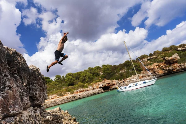 Güneşli Cala Sa Nau, Mallorca, İspanya üzerinde uçurumdan atlama